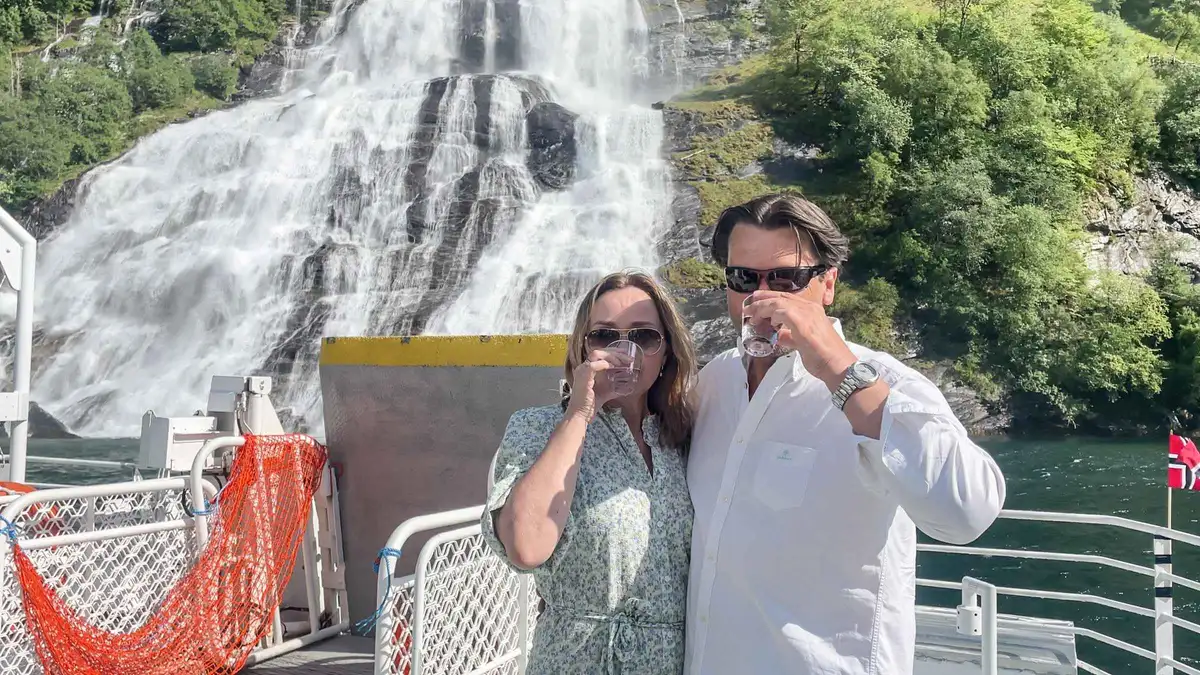 Catamaran passing the Seven Sisters waterfall on a budget Geiranger fjord cruise with waterfall tasting in Norway